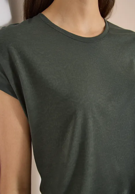 Close-up van een donkergroen T-shirt met korte mouwen gedragen door een persoon