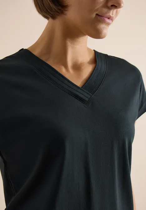 Vrouw draagt een zwart T-shirt met V-hals