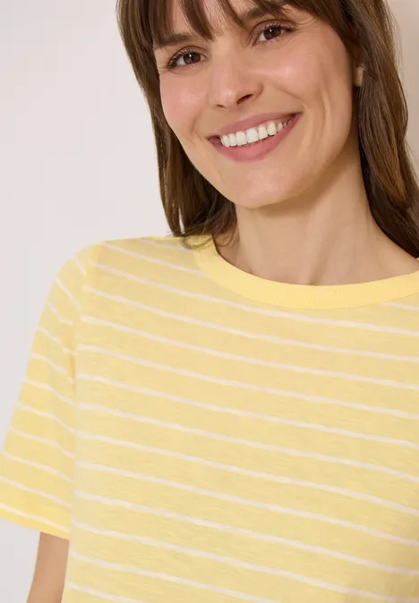 Een lachende vrouw in een geel-wit gestreept T-shirt.