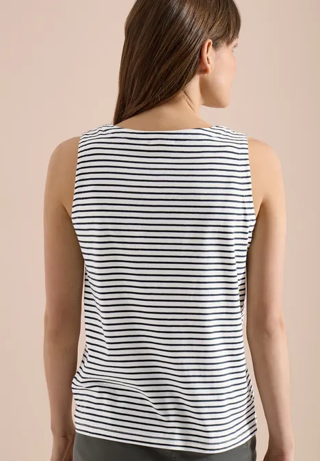 Vue de dos d'une femme portant un haut sans manches à rayures blanches et bleu marine sur fond uni.