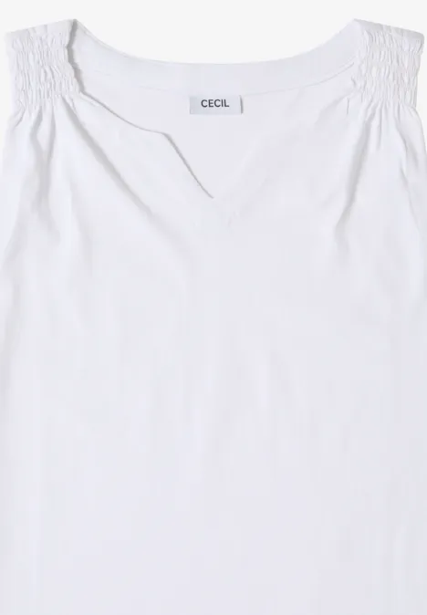 Wit mouwloos topje met V-hals en gerimpelde schouders.