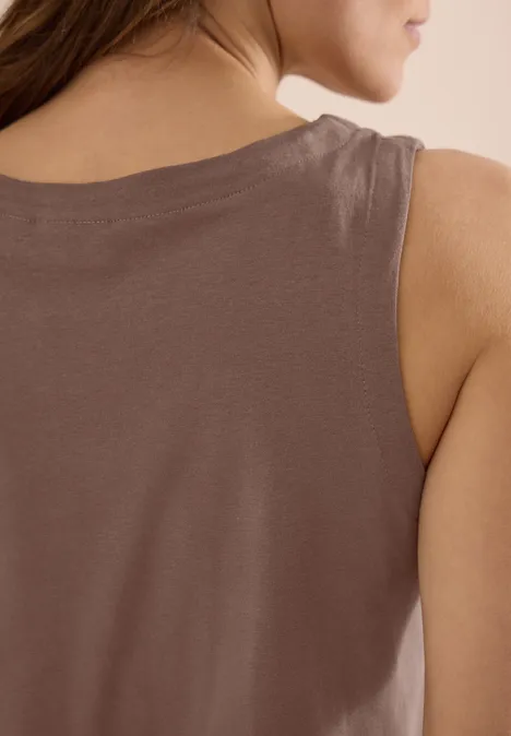 Achteraanzicht van een vrouw in een bruin mouwloos topje