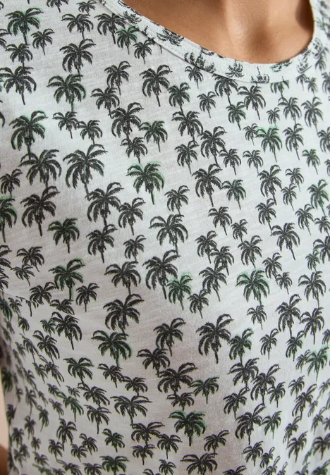 Wit T-shirt met klein, herhalend palmbomenpatroon.