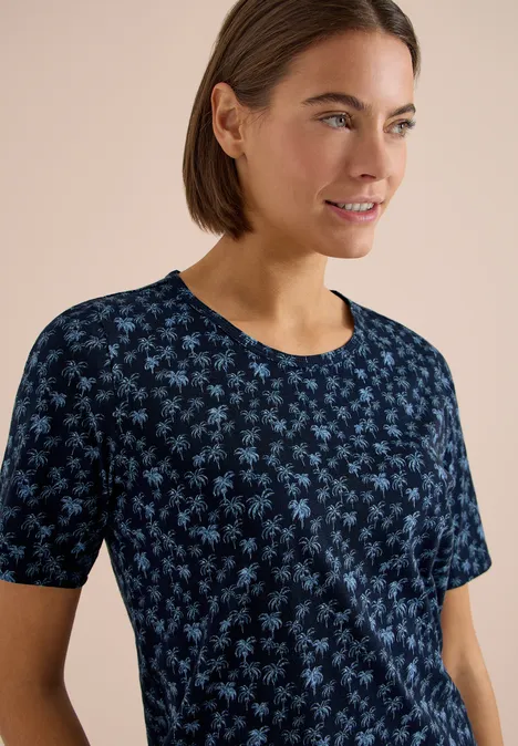 Een persoon draagt een donkerblauw T-shirt met korte mouwen en een licht bloemmotief.
