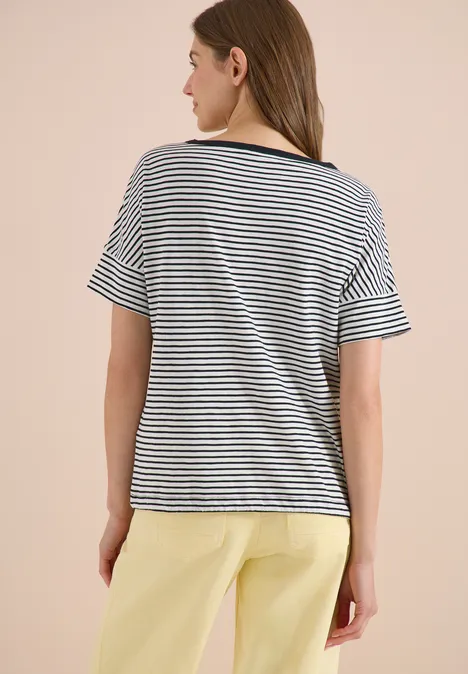 Persoon van achteren met een zwart-wit gestreept T-shirt en pastelgele broek voor een lichte achtergrond.