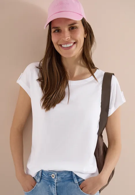 Frau trägt schlichtes weißes T-Shirt mit brauner Tasche