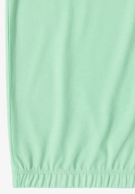 Unterer Teil eines mintgrünen Kleidungsstücks mit elastischem Saum auf weißem Hintergrund.