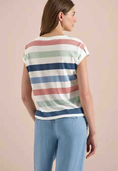 Frau von hinten in pastellgestreiftem T-Shirt und hellblauen Jeans.