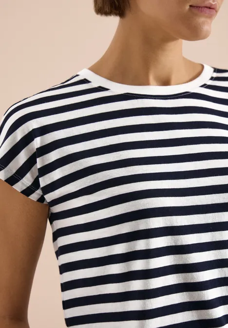 Close-up van persoon met een donkerblauw-wit gestreept t-shirt.