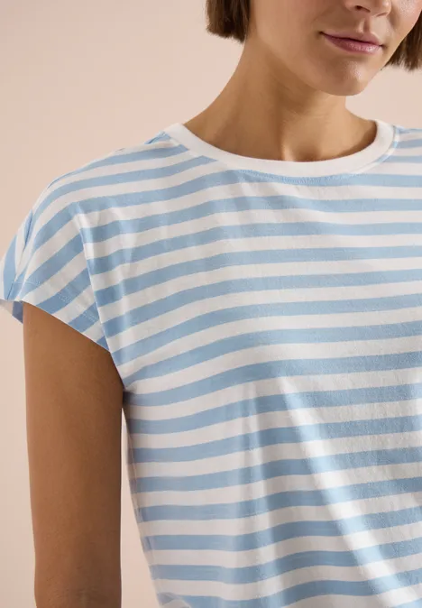Eine Person trägt ein kurzärmeliges Shirt mit hellblauen und weißen Streifen.