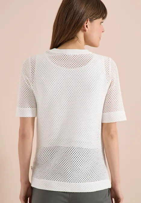 Rückansicht einer Person in weißem, kurzärmeligem Netz-T-Shirt.