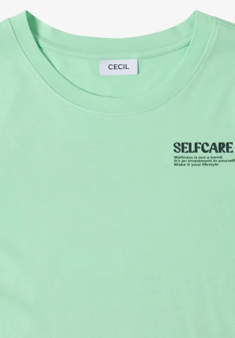 Pastelgroen T-shirt met CECIL-label en SELFCARE-opdruk met slogan op de borst.