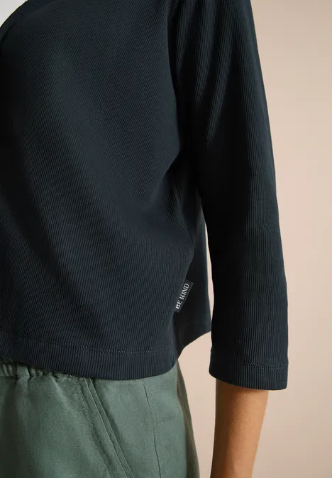 Schwarzer Off-Shoulder-Pullover mit 3/4-Ärmeln und olivgrüner Hose