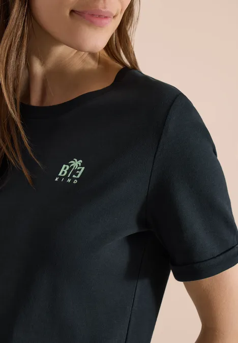 T-shirt noir femme à manches courtes, petit logo vert placé côté gauche de la poitrine.