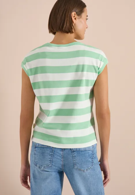 Vrouw van achteren in groen-wit gestreept T-shirt en spijkerbroek