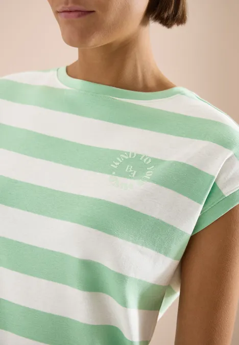 Close-up van een persoon in een wit-groen gestreept T-shirt met klein wit logo.