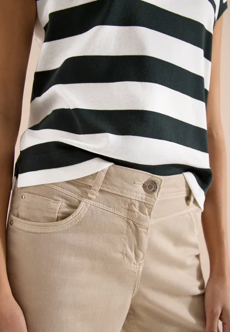 Beige broek en zwart-wit gestreept topje op het vrouwelijke bovenlichaam
