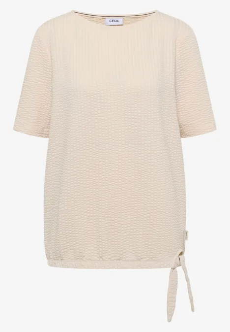 Beige damestop met korte mouwen, gestructureerde stof en zijtrekkoord onderaan.