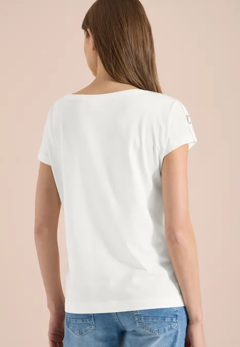 Achteraanzicht van een vrouw in een witte t-shirt en blauwe jeans tegen een neutrale achtergrond.