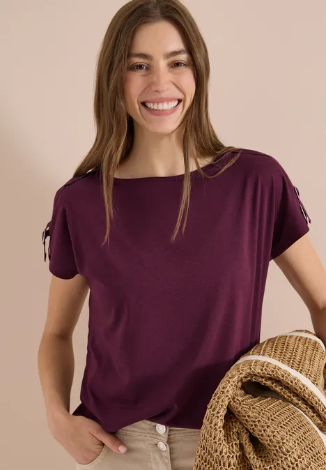 Vrouw in paars T-shirt met strooien hoed. Eenvoudige zomermode.