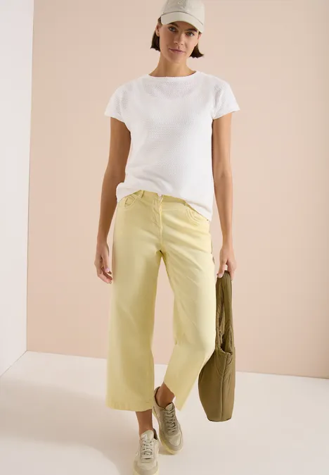T-Shirt mit Boatneck im Ajour-Look vanilla white Junge Frau im weißen T-Shirt und gelben Culottes trägt eine Cap und hält eine olivgrüne Jacke.