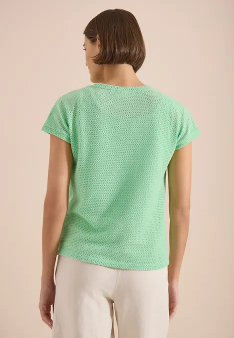 T-Shirt mit Boatneck im Ajour-Look juicy lime Eine Frau von hinten in grünem T-Shirt und heller Hose vor neutralem Hintergrund.