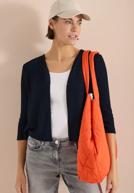 Offene 3/4-Arm Jacke im Ajour-Look universal blue Modisches Model in dunkelblauer Strickjacke, weißem Top, grauen Jeans und orangefarbener gesteppten Tasche