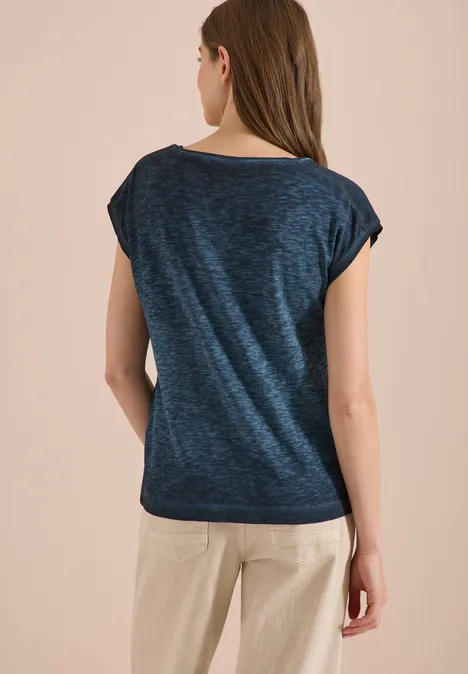 Shirt met boothals in garment-dye look universal blue Vrouw van achteren in donkerblauw shirt en beige broek tegen neutrale achtergrond.