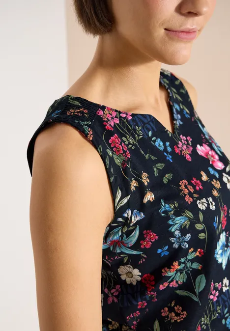 Top mit Split Neck und Raffung universal blue Nahaufnahme einer Frau mit ärmellosem, schwarzem Oberteil mit buntem Blumenmuster.