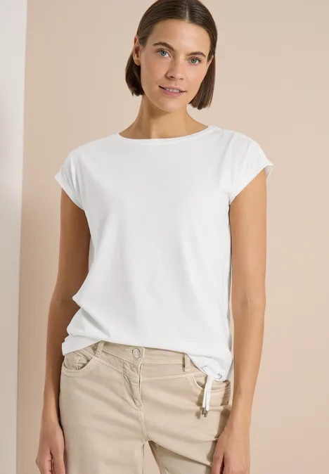 T-Shirt mit Crochet-Details vanilla white Eine Frau trägt ein weißes T-Shirt und beige Hose vor neutralem Hintergrund.