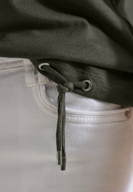 T-Shirt mit Crochet-Details khaki Close-up von weißen Jeans und schwarzem Hoodie mit gebundener Kordel am Saum