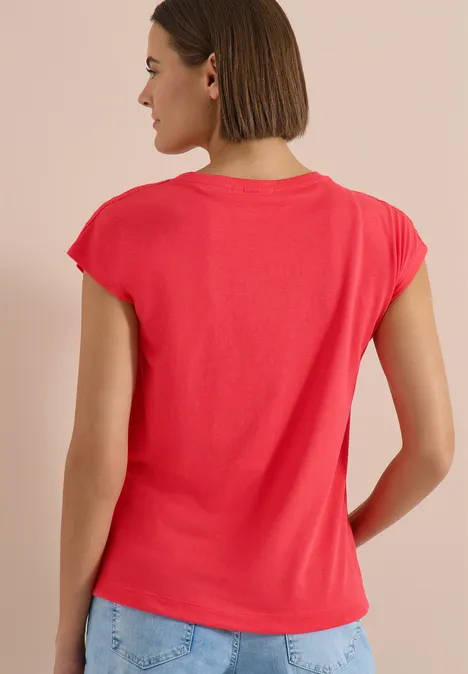 T-Shirt mit Crochet-Details coral Person mit kurzem Bob von hinten trägt rotes T-Shirt mit Cap-Ärmeln vor neutralem Hintergrund.
