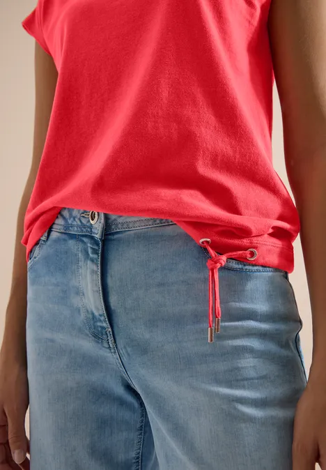 T-Shirt mit Crochet-Details coral Rotes Top und lockere blaue Jeans, seitliche Oberkörperansicht