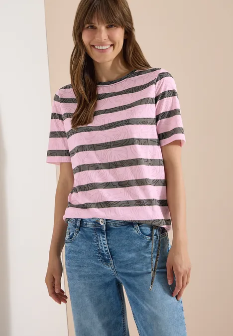 T-Shirt in Ausbrenner-Optik raw khaki Eine Person trägt ein rosa-grau gestreiftes T-Shirt mit kurzen Ärmeln und blaue Jeans.