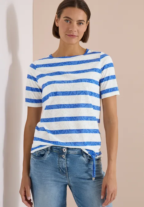 Shirt met burn-out look surf blue Persoon voor neutrale achtergrond met blauw-wit gestreept T-shirt en blauwe spijkerbroek.