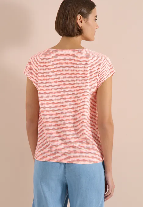 Dame von hinten in rot-weiß gestreiftem T-Shirt und hellblauen Jeans.