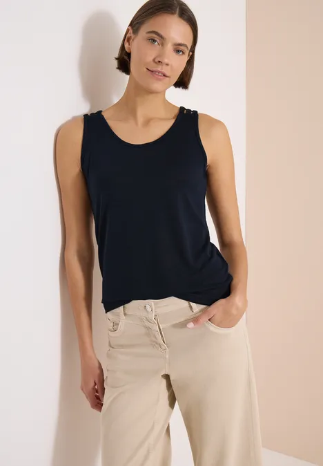 Top met ronde V-hals en gevlochten detail universal blue Een slanke persoon draagt een donkerblauw hemd en een beige broek tegen een lichte achtergrond.