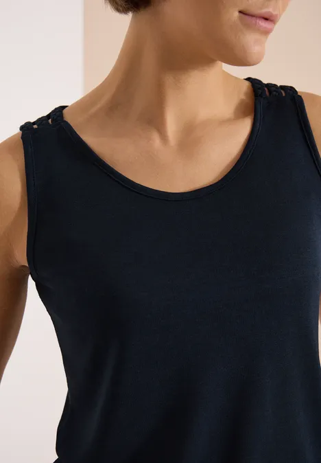 Top met ronde V-hals en gevlochten detail universal blue Een vrouw draagt een donkerblauw mouwloos shirt, focus op nek en schouders.