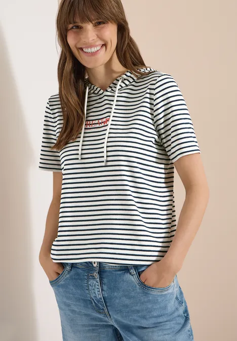 Shirt met korte mouwen, capuchon en glitter vanilla white Vrouw in een gestreepte korte mouw hoodie met capuchon en spijkerbroek.
