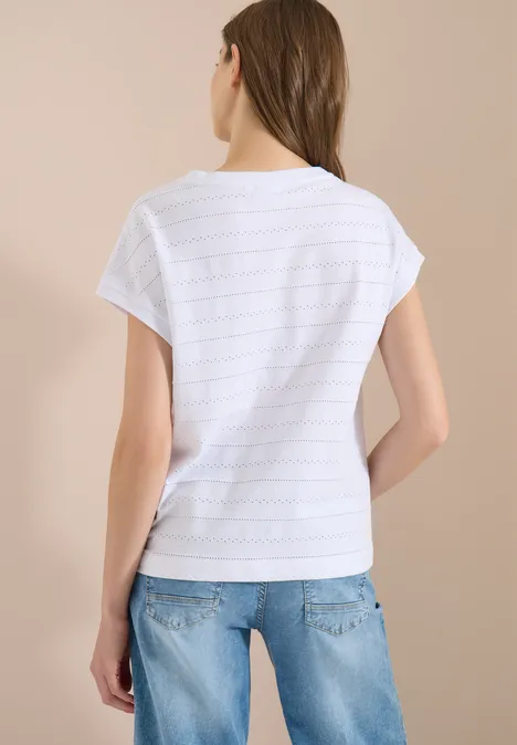 Rückansicht einer Frau in weißem T-Shirt und Jeans vor neutralem Hintergrund.