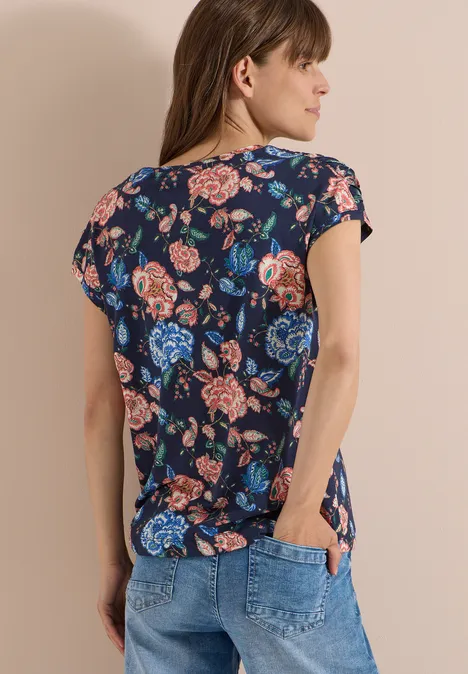 Kurzarm Shirt mit Boatneck und Raffung urban dark blue Frau von hinten in dunkelblauem, geblümtem T-Shirt und Jeans vor hellem Hintergrund.