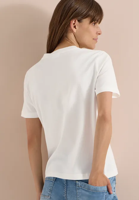 T-Shirt mit Rundhals und Frontprint vanilla white Rückansicht einer Person mit schlichten weißen T-Shirt vor beigem Hintergrund.