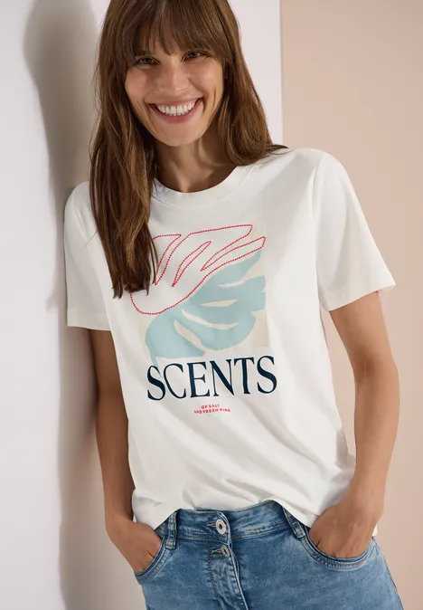 T-Shirt mit Rundhals und Frontprint vanilla white Weißes T-Shirt mit ‚SCENTS‘-Schriftzug und rosa-blauem Grafikmotiv, kombiniert mit Jeans.