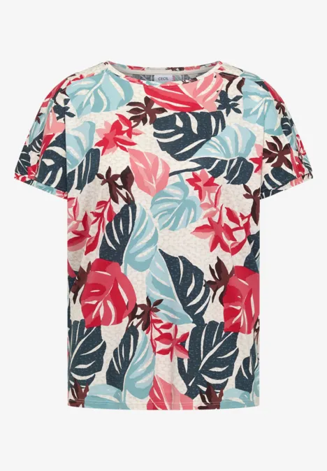 Een crème T-shirt met korte mouwen, bedekt met tropische bladeren in rood, blauw, mint en bruin.