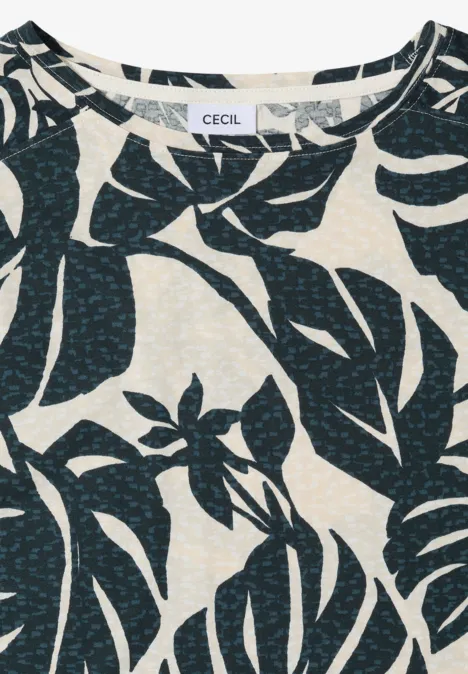 Licht shirt met donkerblauw tropisch bladmotief op een crèmekleurige achtergrond.