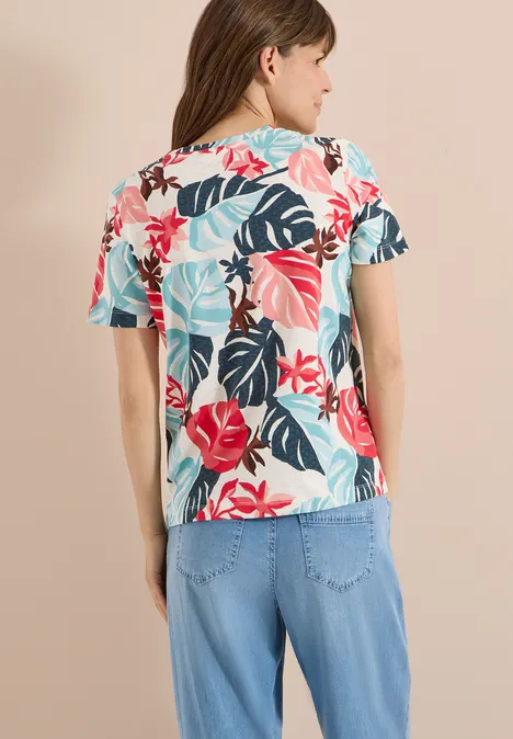 T-Shirt mit Rundhals und Blätterprint light alabaster white Rückansicht einer Person in hellblauer Jeans und floraler Kurzarmbluse mit tropischem Muster