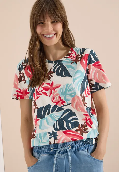 T-Shirt mit Rundhals und Blätterprint light alabaster white Frau trägt T-Shirt mit tropischem Blumen- und Blattmuster