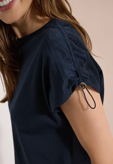 T-Shirt mit Raffung in Unifarbe universal blue Frau trägt dunkelblaues T-Shirt mit Spitzen-Detail am Ärmelsaum und Kordelzug.