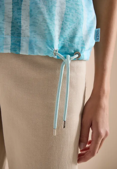 T-Shirt in Ausbrenner-Optik crystal mint Türkis gestreiftes Top mit Tunnelzug am Saum und Kordeln, kombiniert mit beiger Hose.