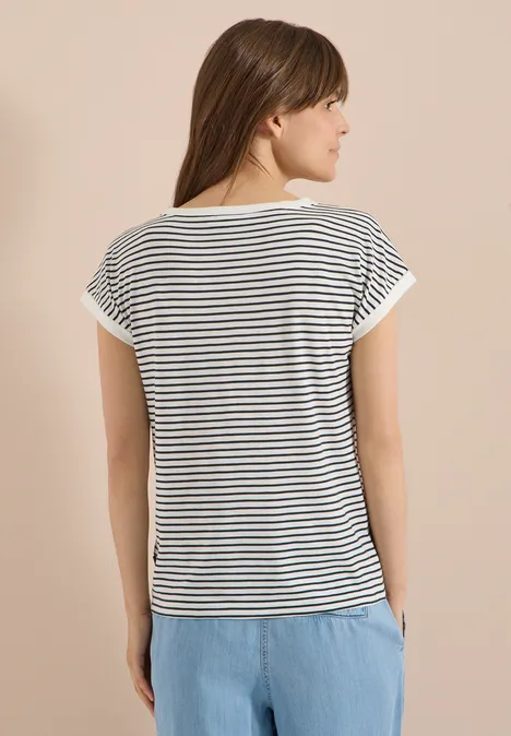 T-Shirt mit Boat Neck und Streifen palm breeze green Rückenansicht einer Frau in weiß-schwarz gestreiftem T-Shirt und hellblauer Hose vor hellem Hintergrund.